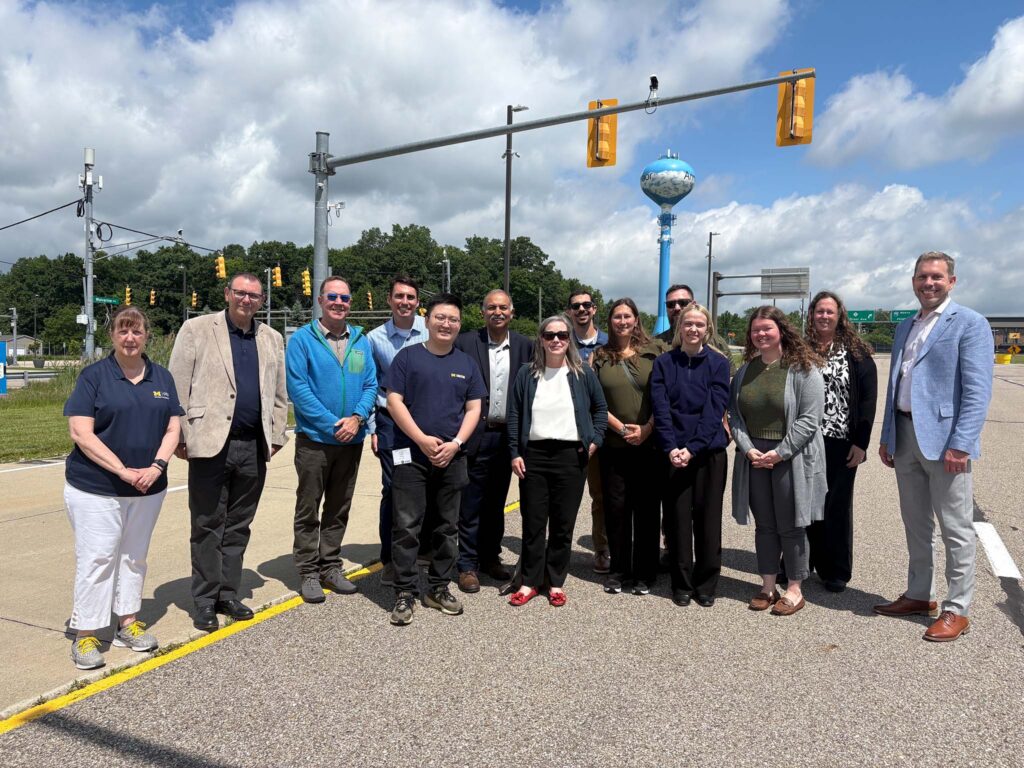 University of Michigan and Federal Highway Administration leadership stand together at the Mcity Test Facility
