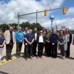 University of Michigan and Federal Highway Administration leadership stand together at the Mcity Test Facility